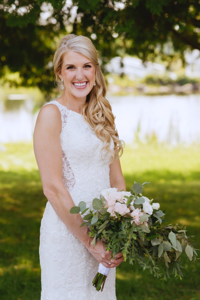 bride smiling at the camera holding bouquet