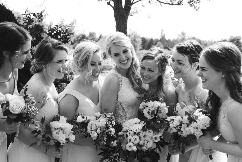 bride and bridesmaids laughing in black and white