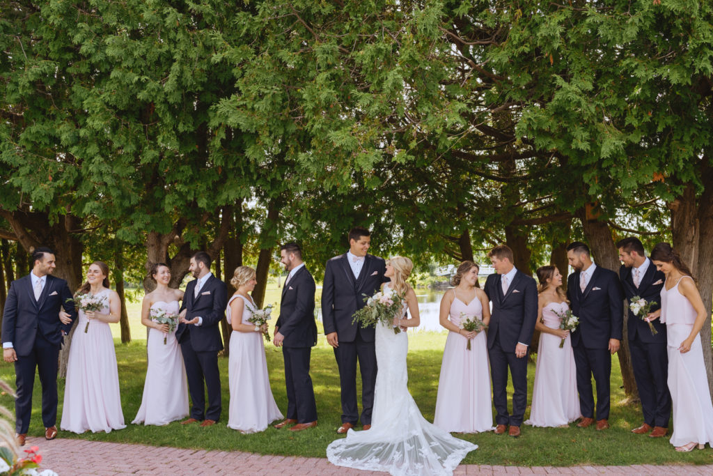 wedding party standing underneath trees