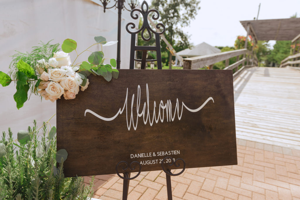 wood sign that says 'welcome' at outdoor wedding