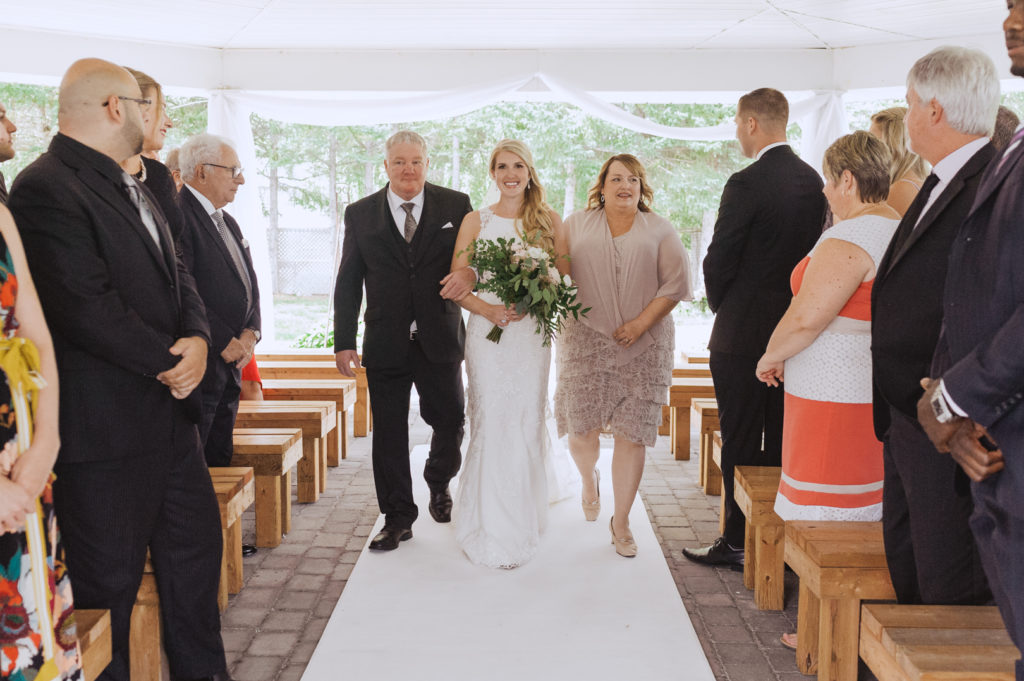 bride walking down the aisle with her parents
