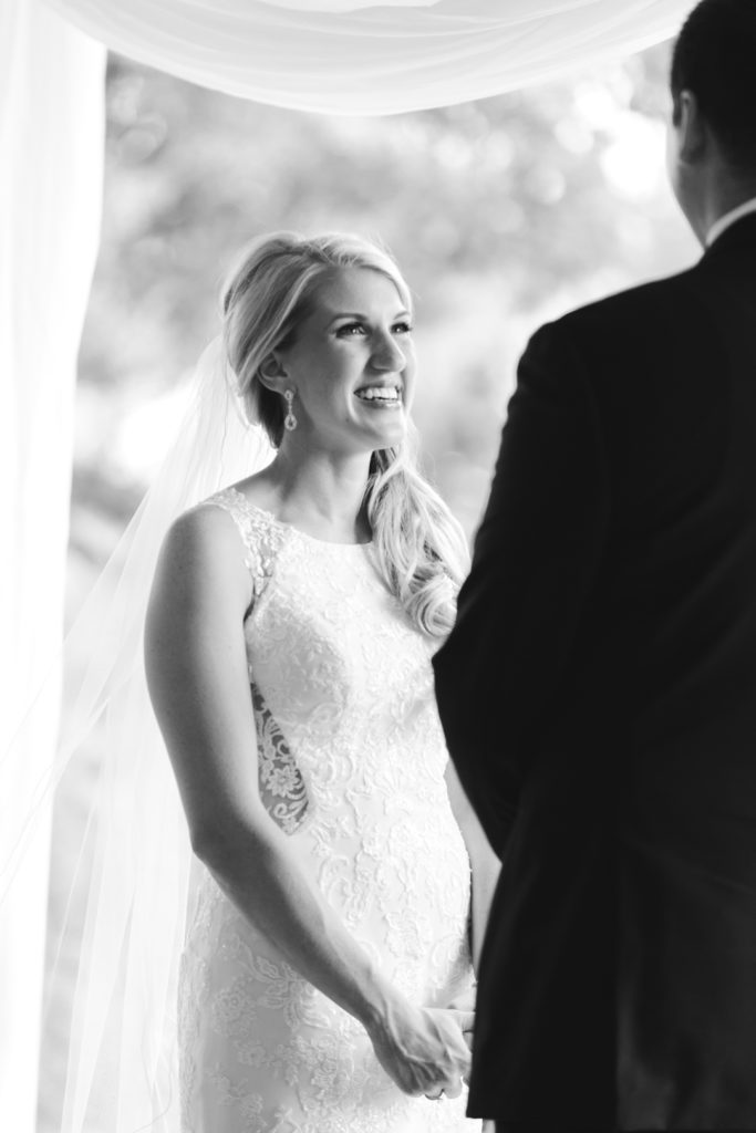 bride smiling at the groom during wedding ceremony