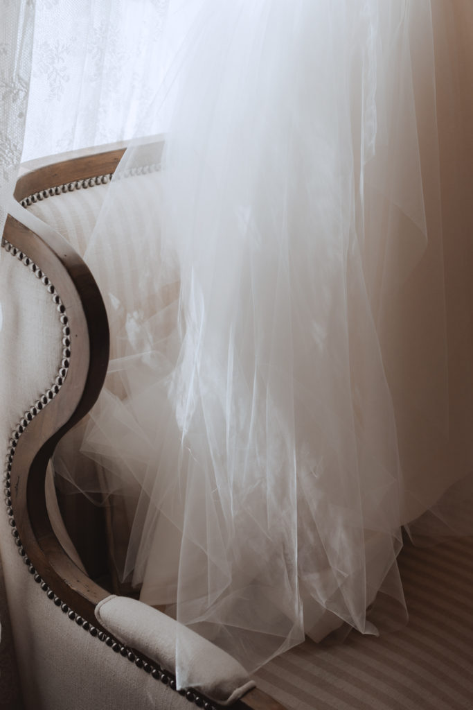 sun hitting tulle of wedding dress on couch