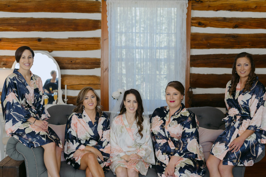 bridesmaids sitting on couch in floral robes