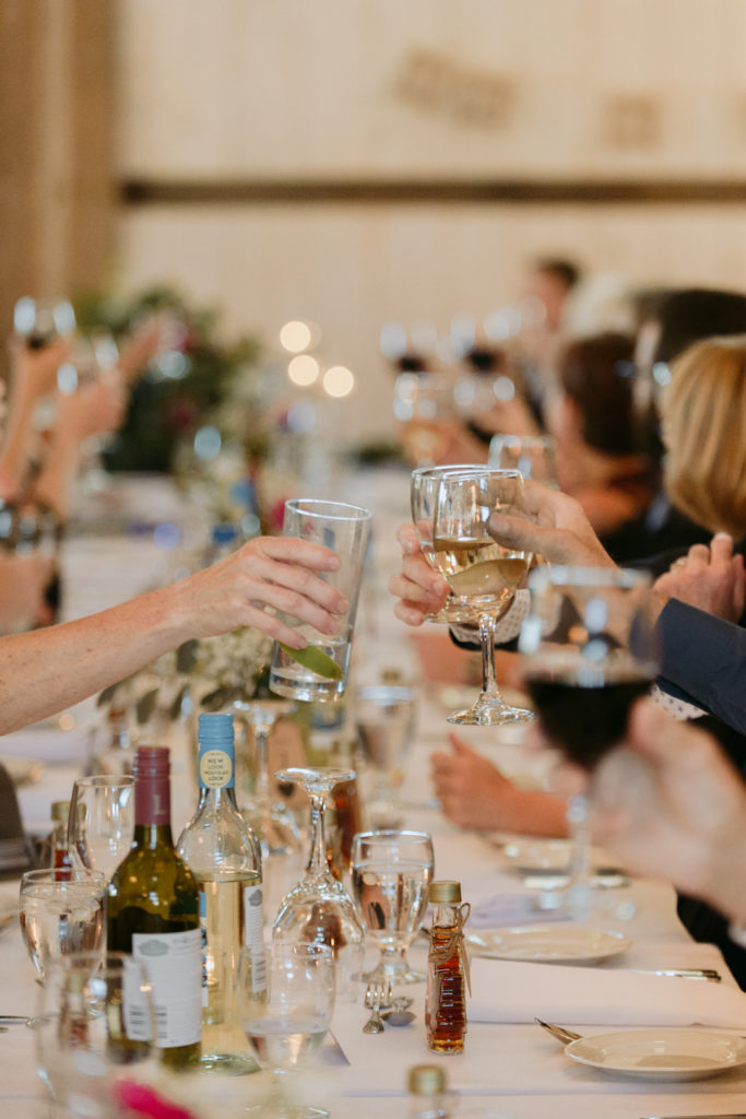 guests cheersing at long harvest table