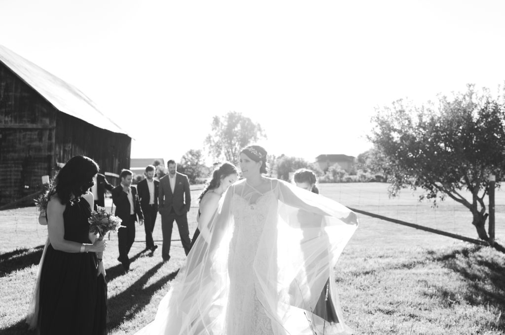 bride adjusting her wedding cape