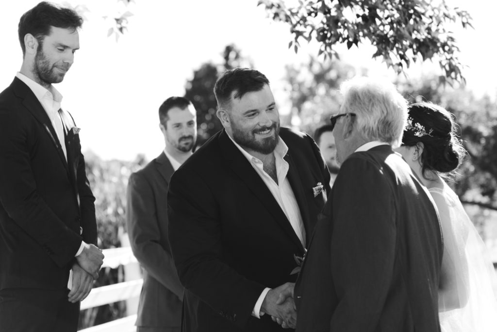 groom shaking the father of the bride's hand