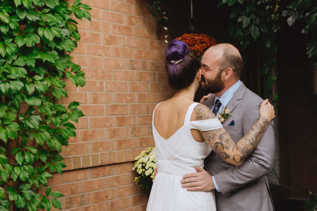 groom kissing his bride at first look
