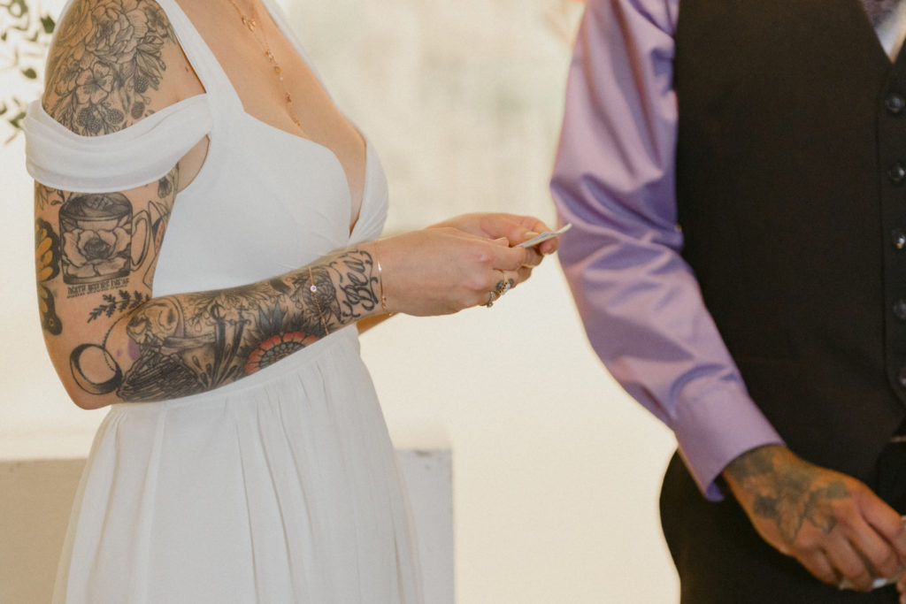 tattooed bride holding vows