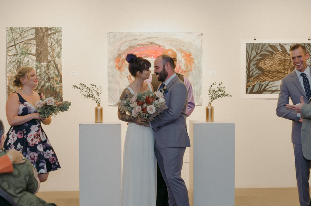 bride and groom smiling after ceremony at art gallery