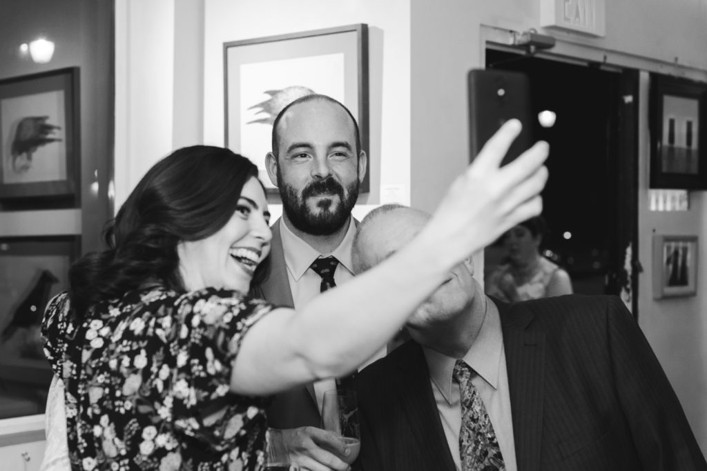 wedding guests taking a selfie with the groom