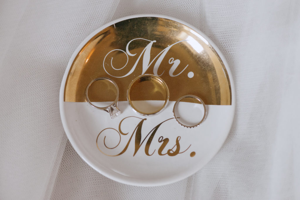 wedding rings on a Kate Spade white and gold Mr. and Mrs. dish