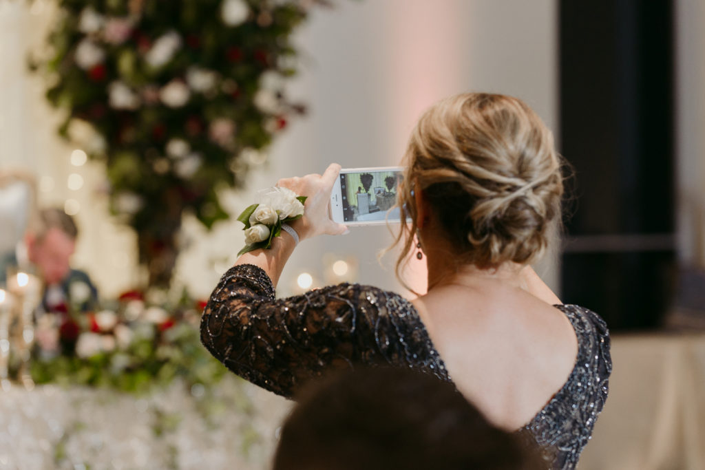 mother of the bride taking a photo on her iPhone