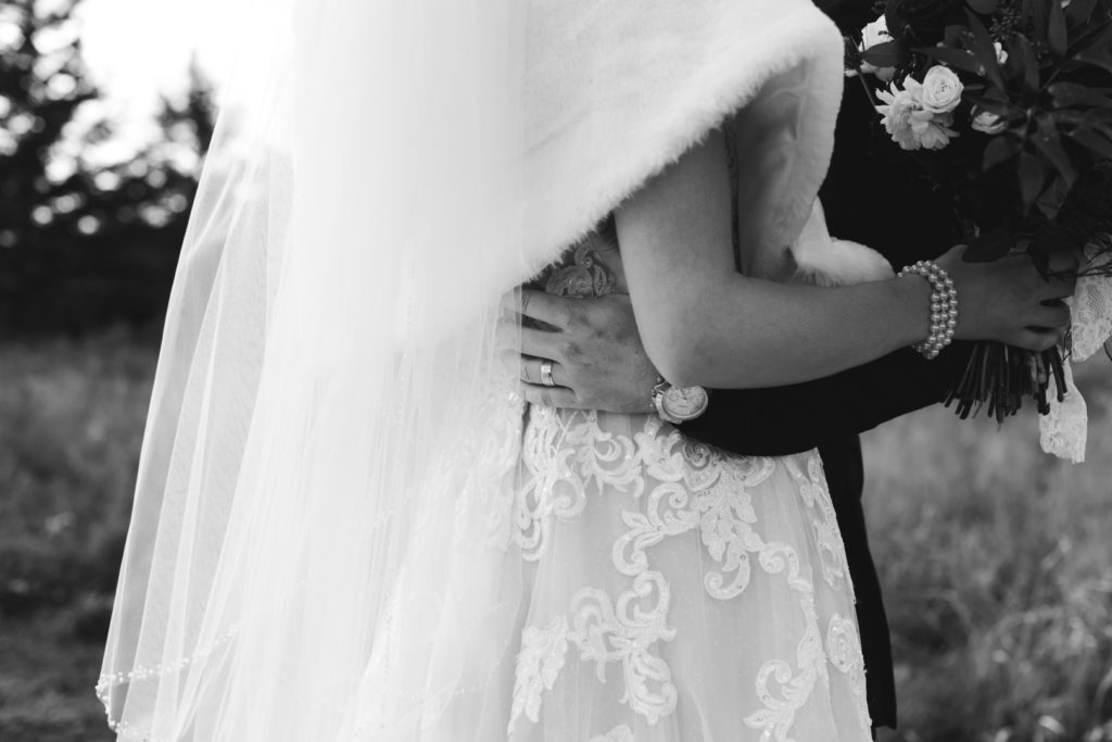 groom's arm wrapped around the bride's waist