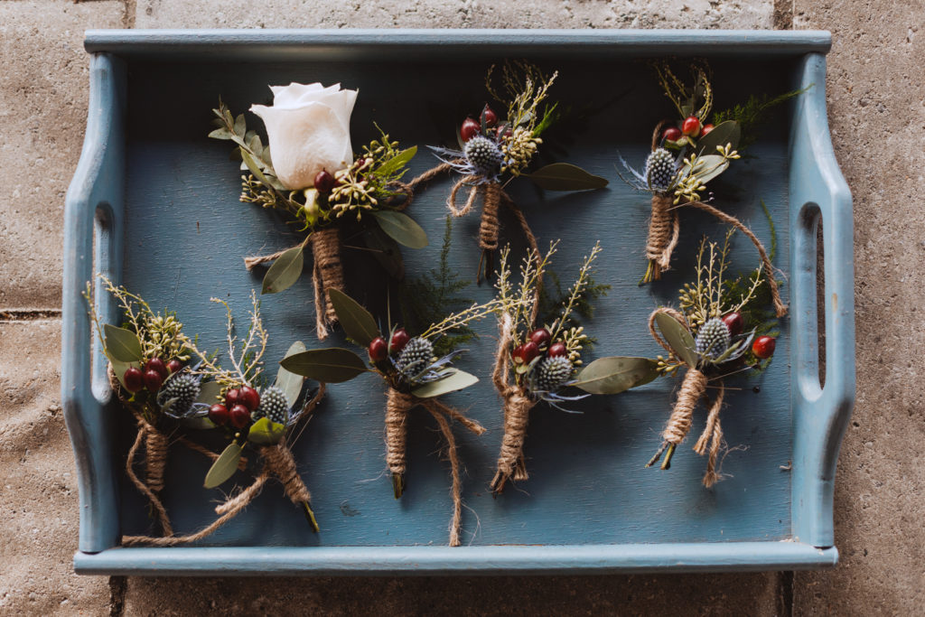 boutonnieres in a blue wooden tray