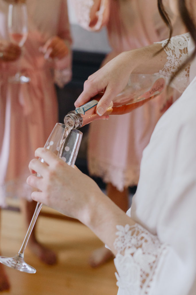 bride pouring champagne into champagne flute