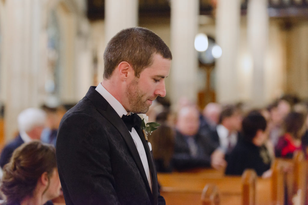 groom trying not to cry as his bride walks down the aisle