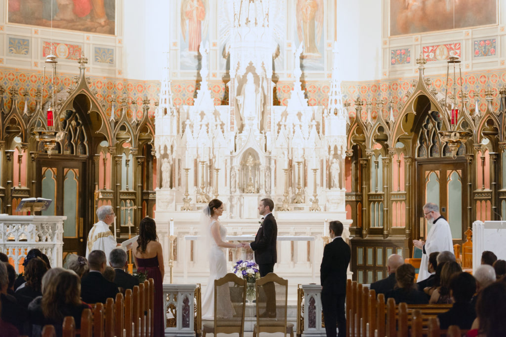 bride and groom exchanging rings during church ceremony
