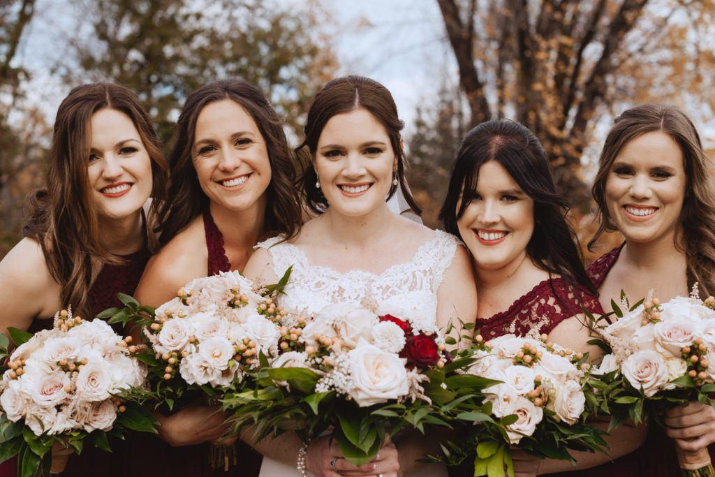 bride and bridesmaids smiling holding bouquets