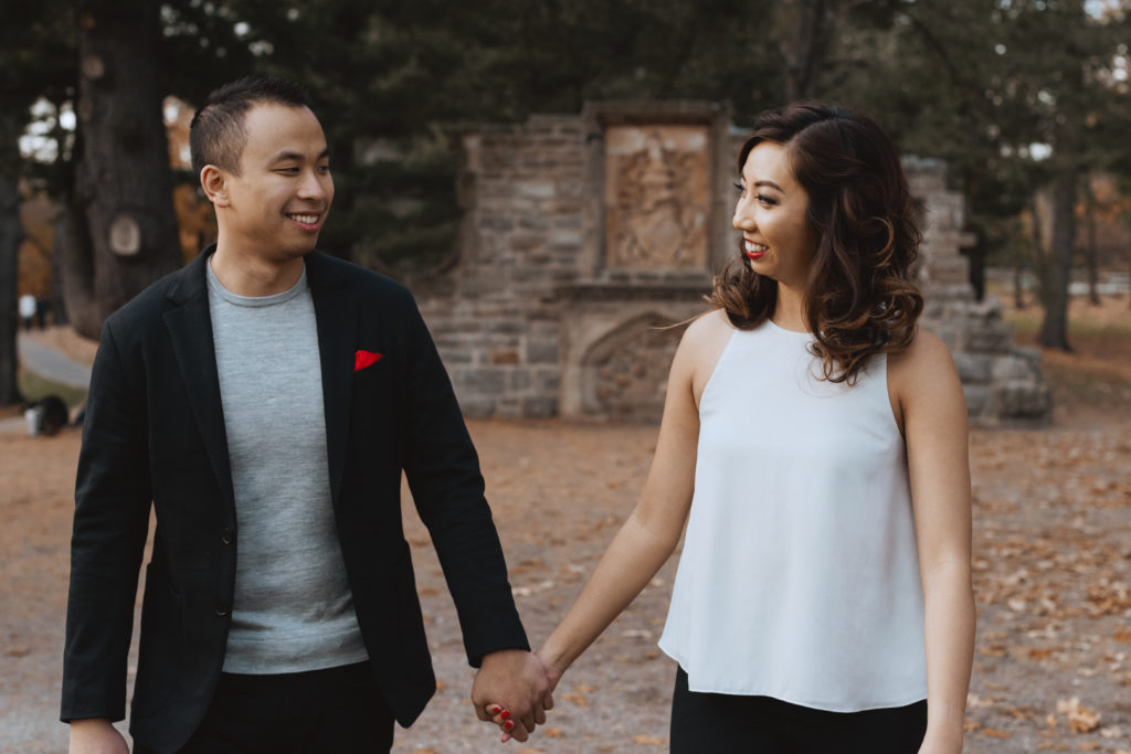 engaged couple holdings hands walking through ruins of Mackenzie King Estate