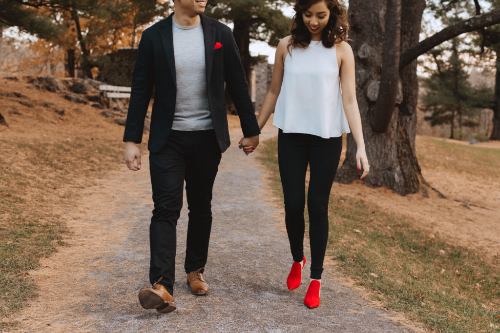 engaged couple holding hands walking down path at Mackenzie King Estate