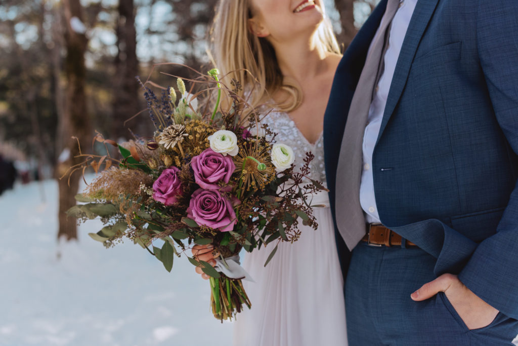bride holding wild bouquet in the winter woods