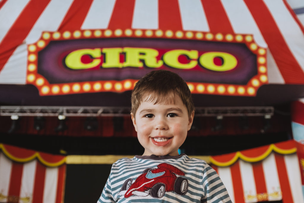 toddler in front of circus sign