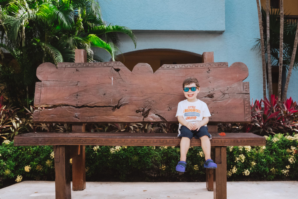 boy sitting on a bench with sunglasses on