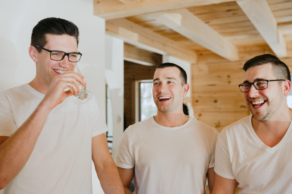 groom and groomsmen laughing while getting ready