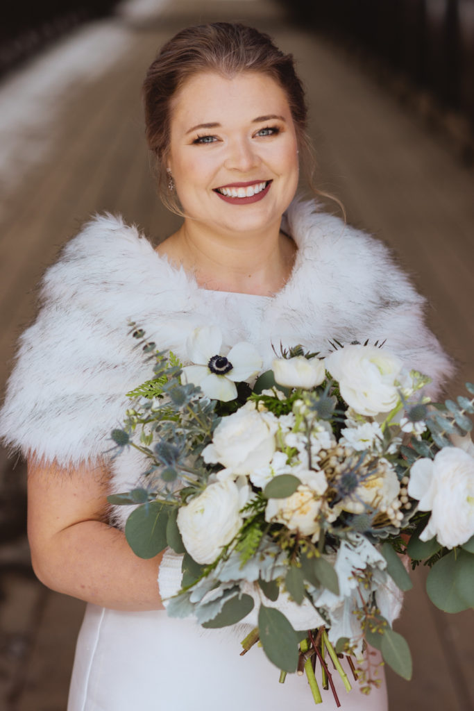 bride wearing a fur holding wedding bouquet
