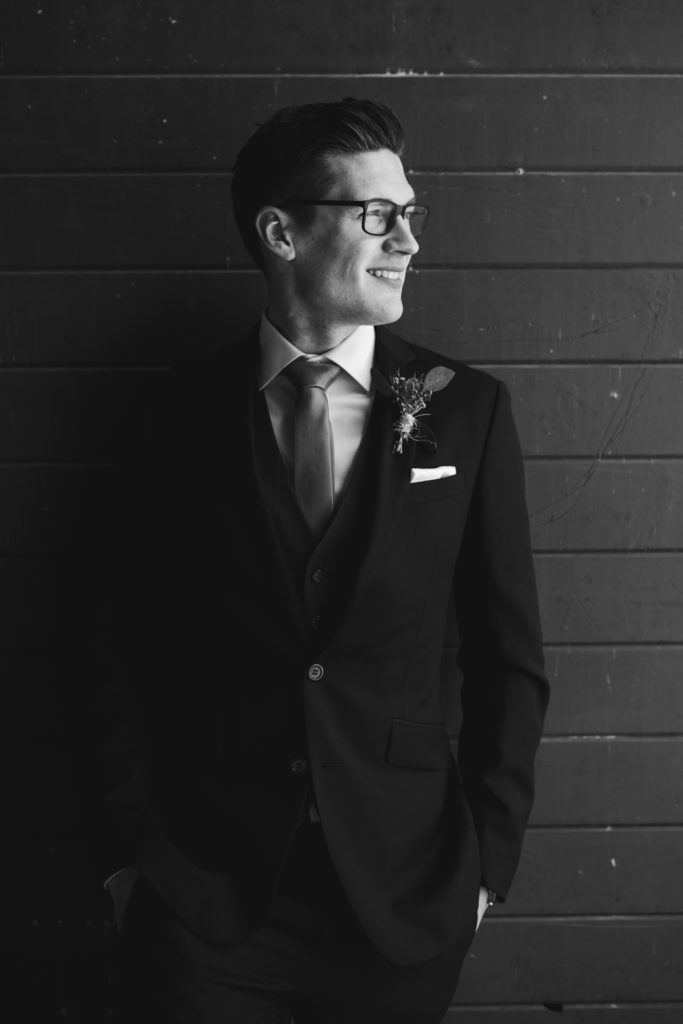 groom looking into the light in black and white
