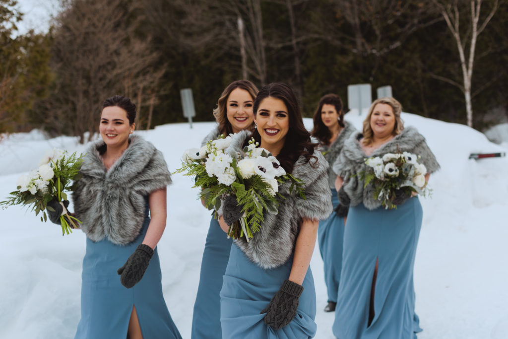 bridesmaids in blue carrying bouquets