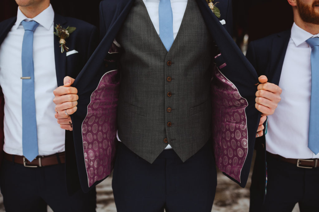 groom holding open his suit jacket with fancy silk lining
