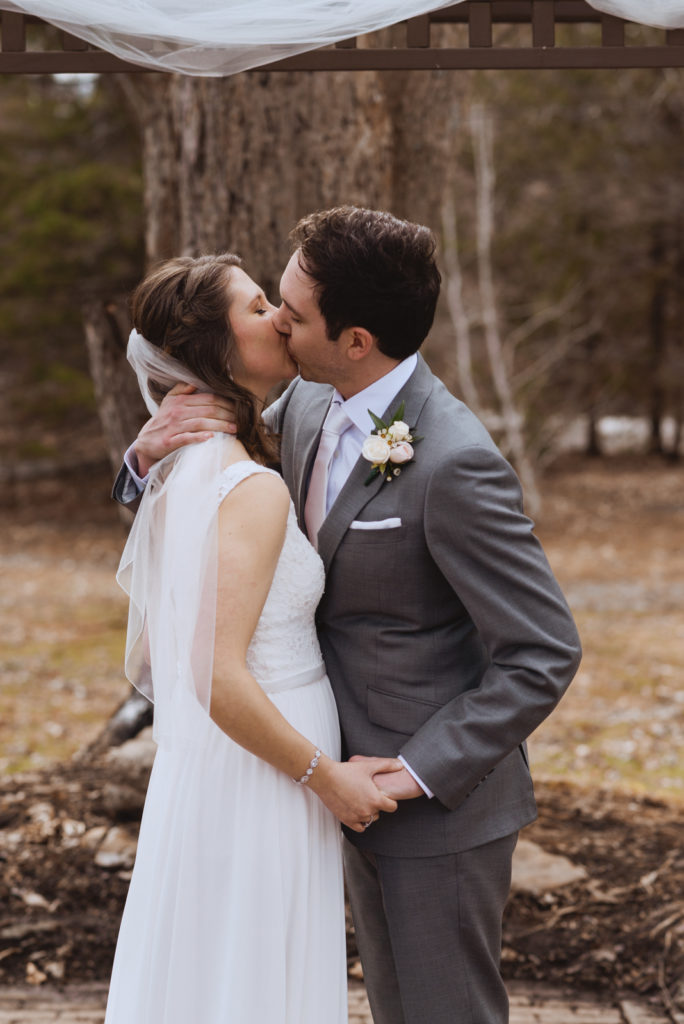 first kiss at outdoor spring wedding