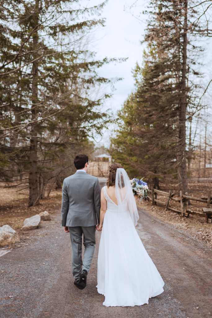bride and groom walking down a dirt road