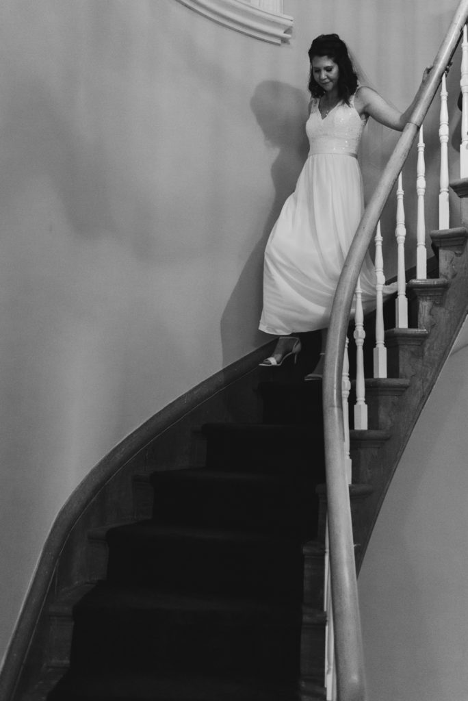 bride coming down spiral staircase in black and white