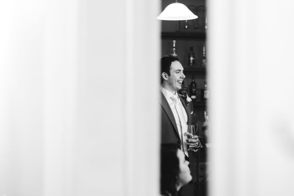 groom laughing holding a drink