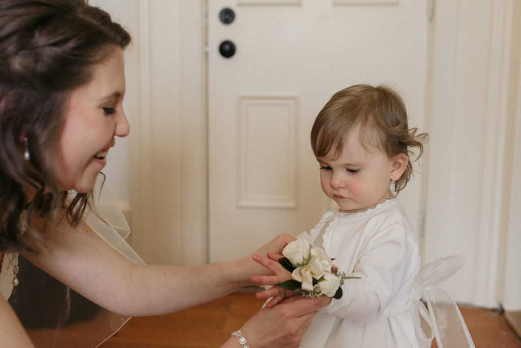 bride putting on her daughter's corsage