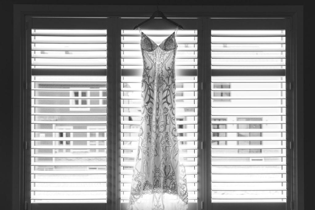 bride's dress hanging in the window in black and white