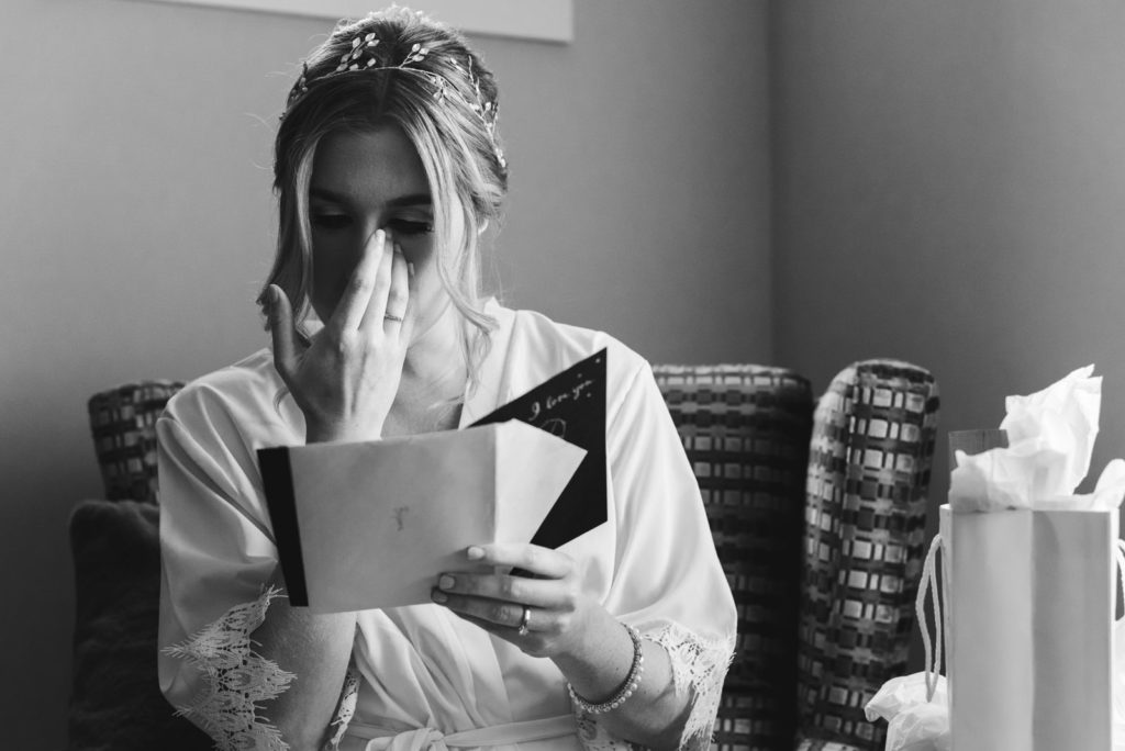 bride reading a card from the groom wiping away a tear