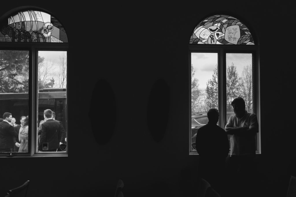 silhouette of priest by the church window