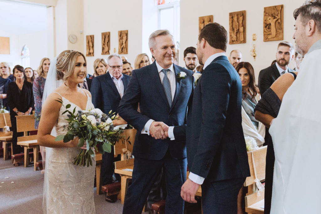 bride's father shaking the groom's hand before giving away his daughter