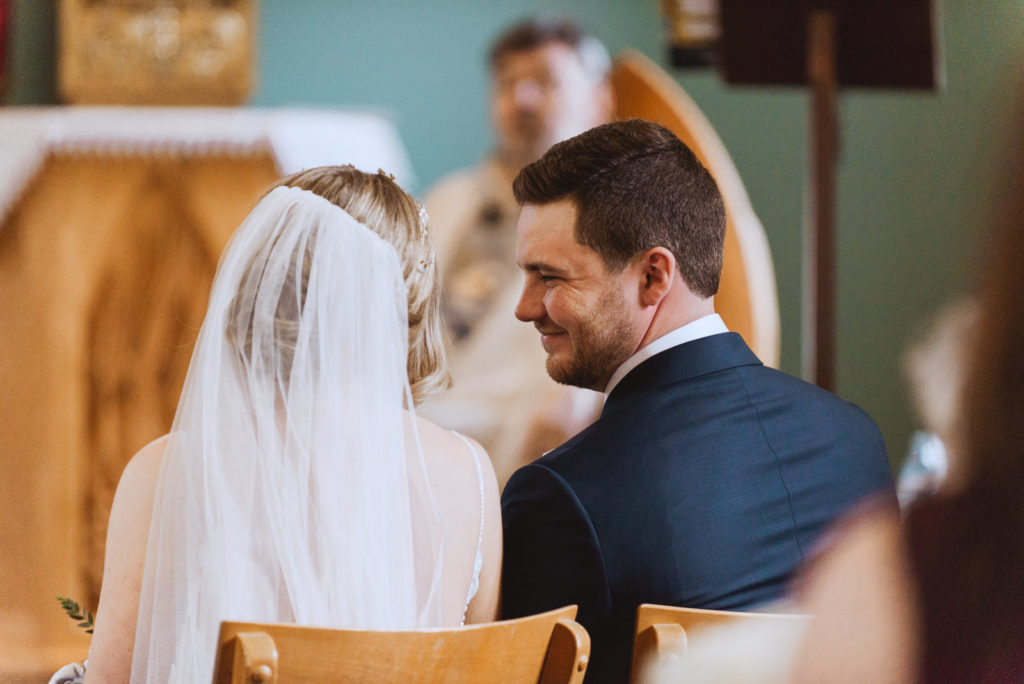 groom smiling at the bride during church wedding