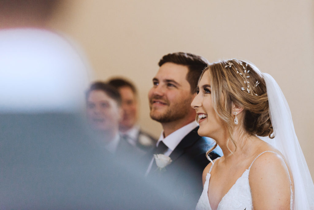 bride and groom laughing during church ceremony