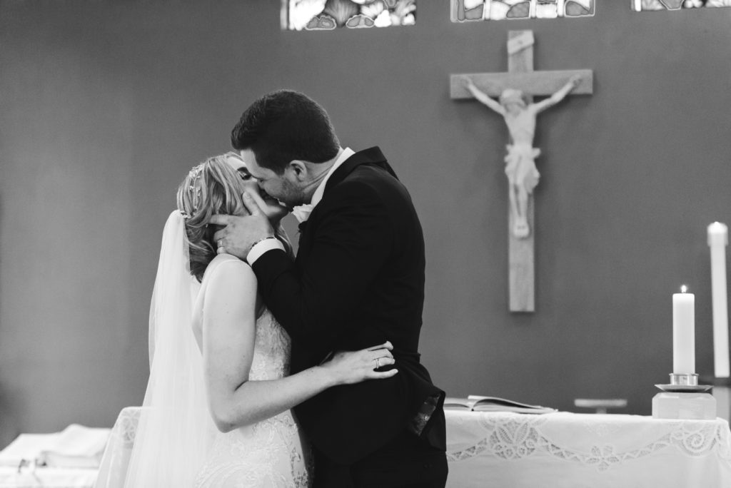 bride and groom first kiss at church ceremony
