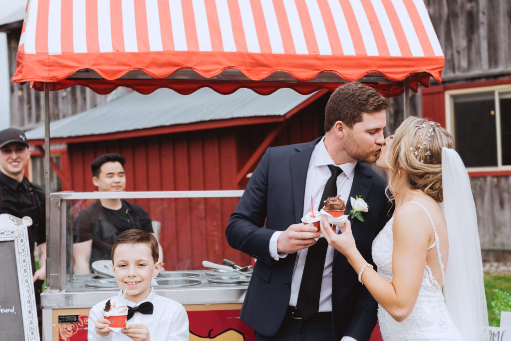 bride and groom kissing outside of stella luna cart at wedding