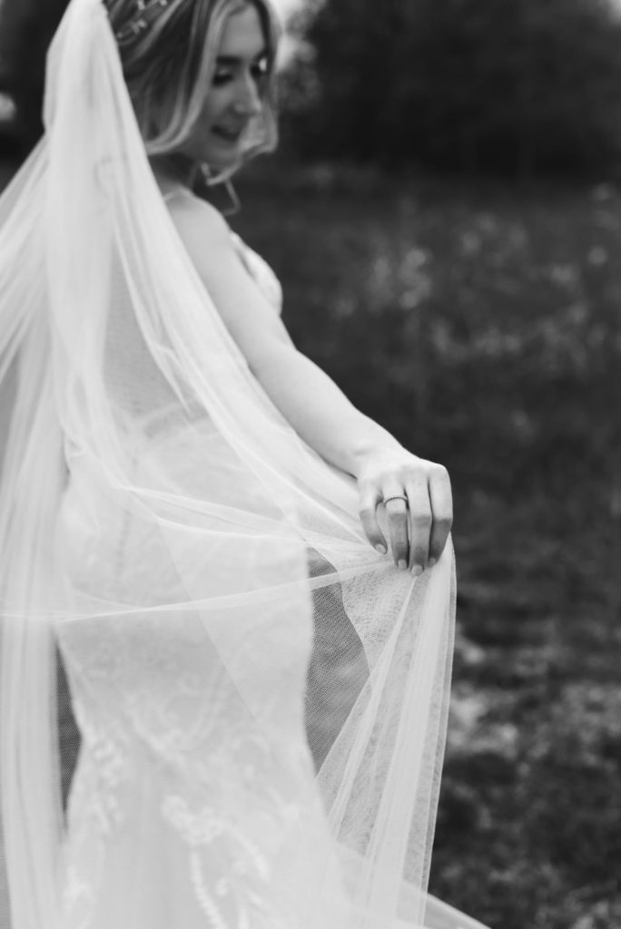 bride playing with her veil in black and white