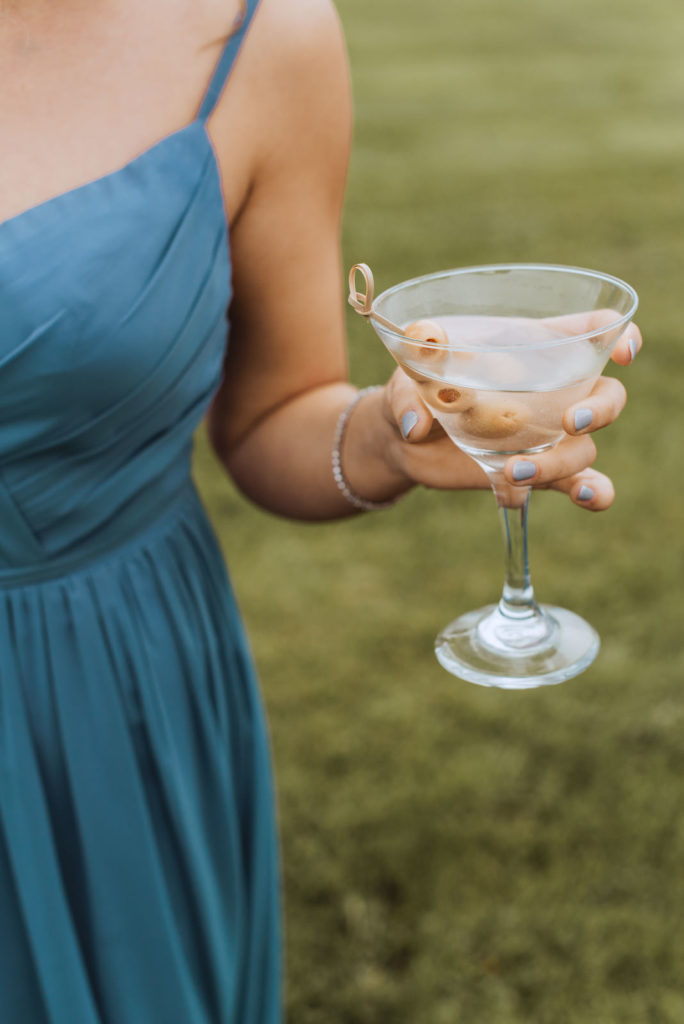 bridesmaid drinking a dirty martini with olives