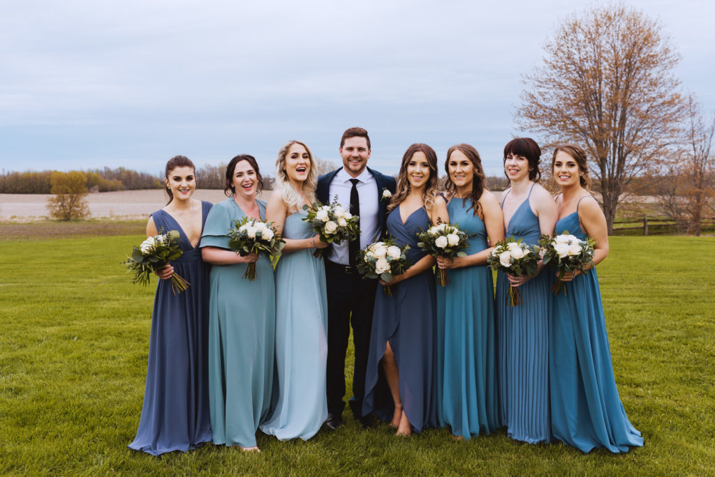 groom with bridesmaids in the fields of strathmere
