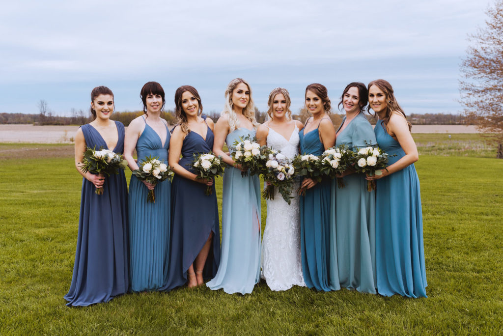 bride and bridesmaids wearing different shades of blue in the fields of strathmere